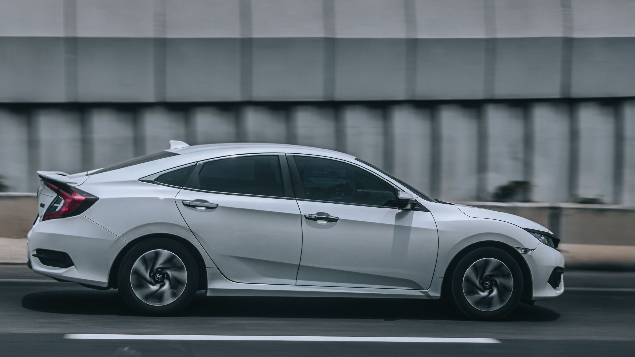 Carro híbrido HEV em tráfego urbano, ilustrando o uso no dia a dia da cidade onde o sistema autorrecarregável rende mais economia