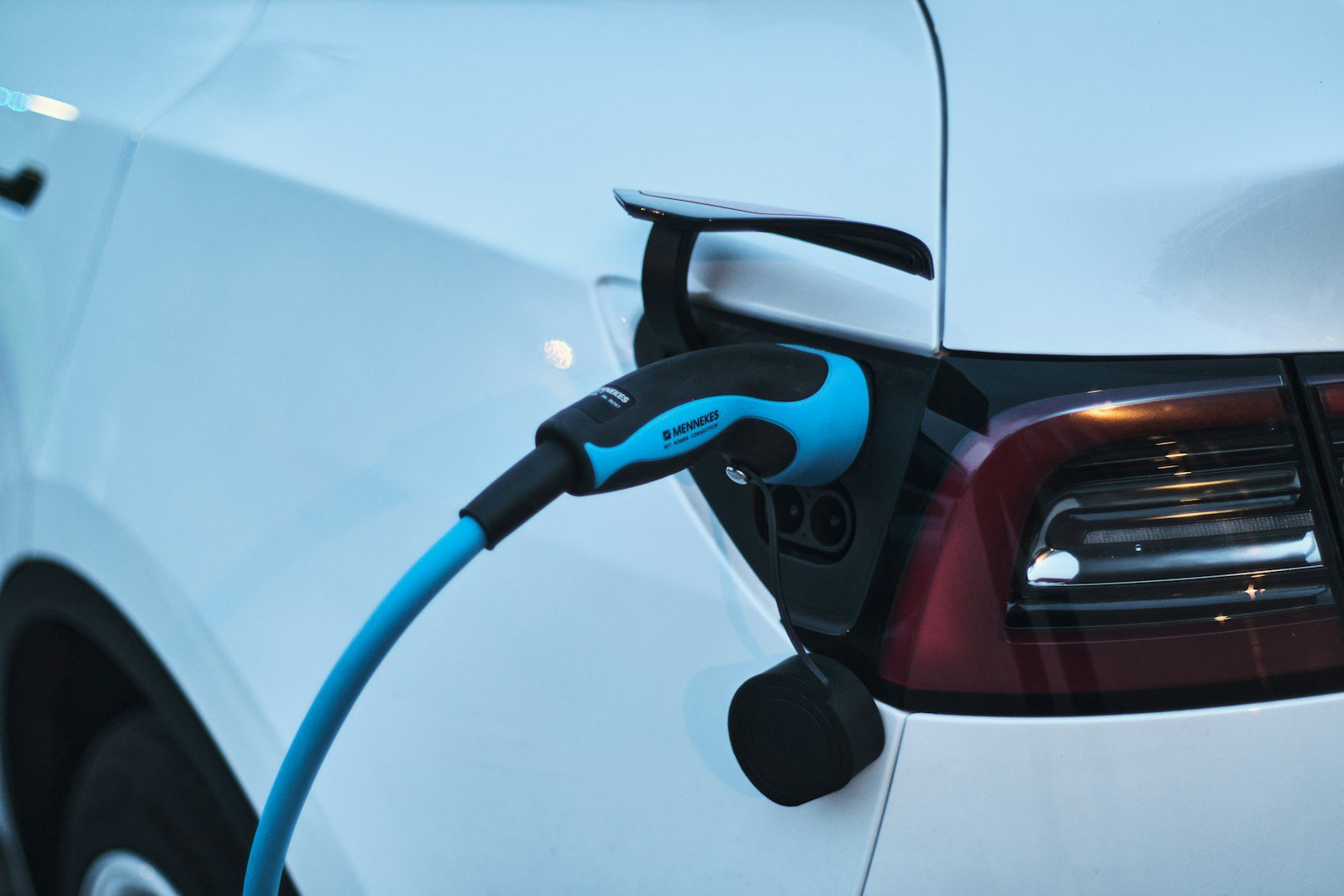 Carro elétrico azul conectado a um carregador em um eletroposto
