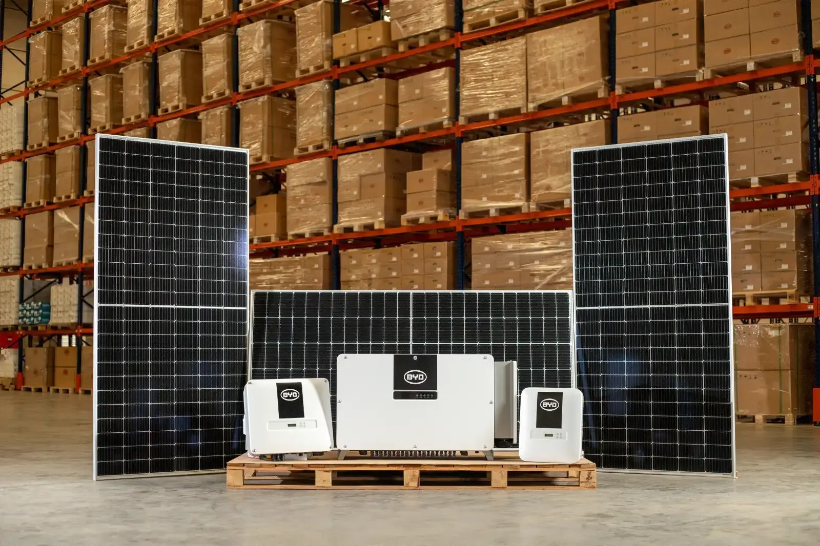 Painéis solares e inversores da BYD expostos em um galpão, componentes do kit solar vendido nas concessionárias
